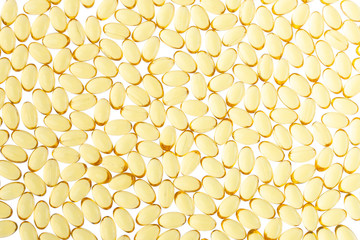 Softgels of Omega-3 on isolated background. Texture of yellow capsules on isolated white background. Medical medicament of polyunsaturated fatty acids. Fish oil capsules, close up.