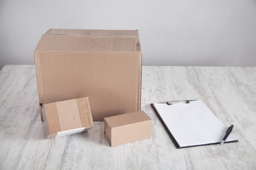 Cardboard boxes with clipboard on the desk. Products, Commerce, Retail, Delivery