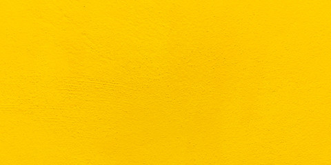 Blurred Yellow stucco wall background. Yellow painted cement wall texture.