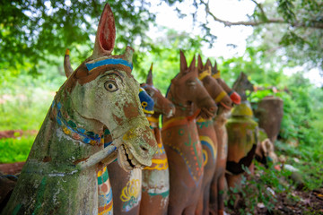 Decorative painted terracotta horses surround a temple in Narthamalai village