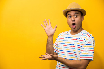 Young asian men celebrity with hands palm up in the air on studio yellow background.