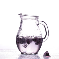 decanter with ice berries and water on a white background