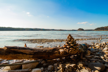 panoramic picture of the "Ostersee", located near Seeshaupt in bavaria, with a pinecone in the foreground