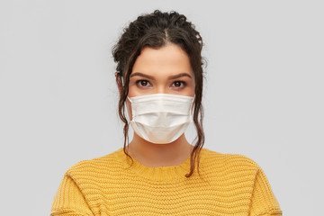 health protection, safety and pandemic concept - portrait of young woman in protective medical face...