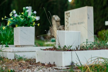 Small children gravestone. Focus on the granite vase in front, actual tombstone with inscription out of focus