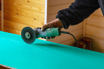 In the manâ€™s hands is a cutting machine.