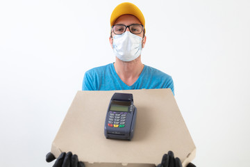 Fototapeta na wymiar Delivery guy with protective mask holding pizza box and POS for contactless payment.