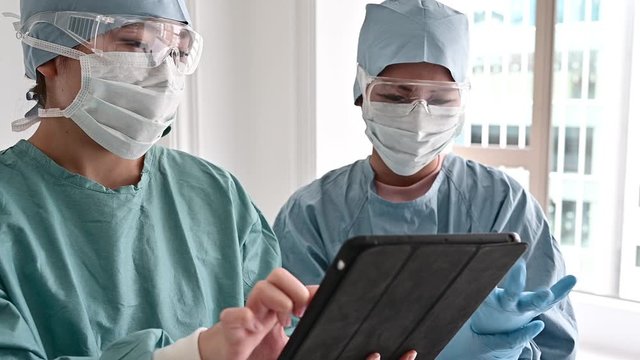 タブレットを使って会議をする医師チーム