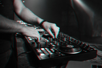 DJ mixes music on a professional controller Board in a nightclub at a party