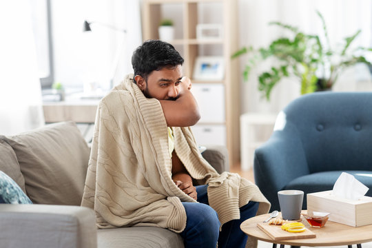 Health, Cold And People Concept - Sick Young Indian Man In Blanket Coughing At Home