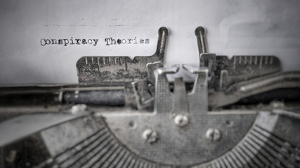 Conspiracy Theories text typed on blank paper with old typewriter in vintage background