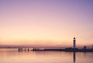 Panorama of harbor lighthouse landscape, pink sky at sunset, copy space