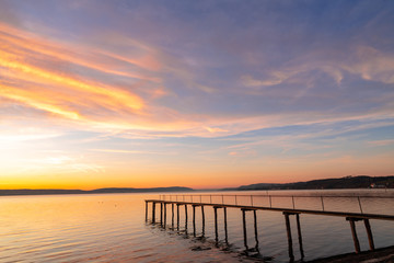 Naklejka na ściany i meble Pier and bridge on the sea, beautiful sunset, dramatic sky background