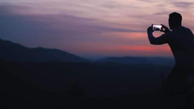 Dark Silhouette Outline of Man Taking Sunset Nature Photo with Phone