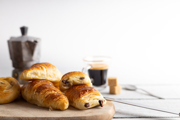 Breakfast table with croissants and cinnamon buns with fresh orange juice.