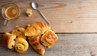 Breakfast table with croissants and cinnamon buns with fresh orange juice.