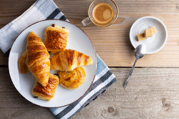 Breakfast table with croissants and cinnamon buns with fresh orange juice.