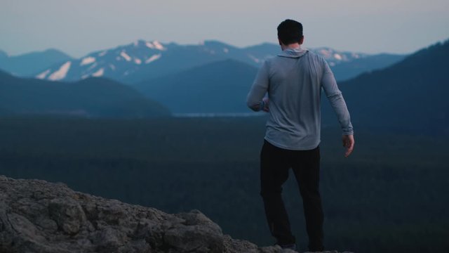Fit Young Jogger Runs to Mountain Lookout and Holds Arms Out