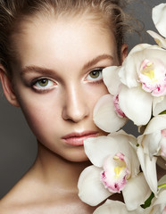 Beauty portrait of girl with orchid flowers