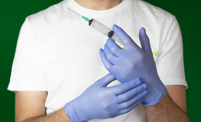 Fototapeta na wymiar doctor in blue medical gloves holding syringe with needle closeup