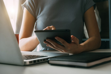 businessman working with digital tablet computer and smart phone with financial business strategy layer effect on desk in morning light
