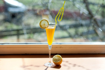 yellow cocktail with lemon in a glass
