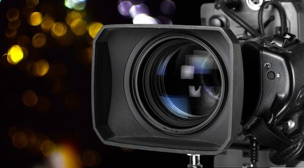 Fototapeta na wymiar Professional video camera on dark background
