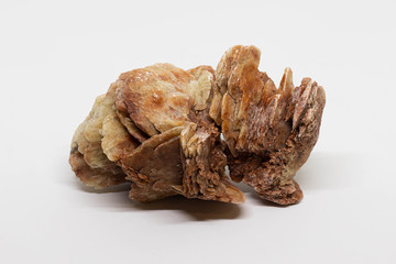 Desert rose. Natural rose-like crystal made from sand isolated on white background