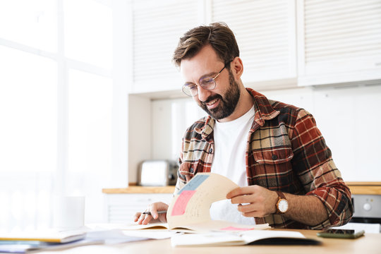 Portrait of excited bearded man smiling while working at home - Powered by Adobe