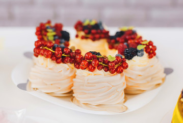 pink cakes with red berries lie on a white plate