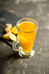 Healthy hot beverage with lemon, ginger and spices for protection in flu season. Selective focus. Shallow depth of field.