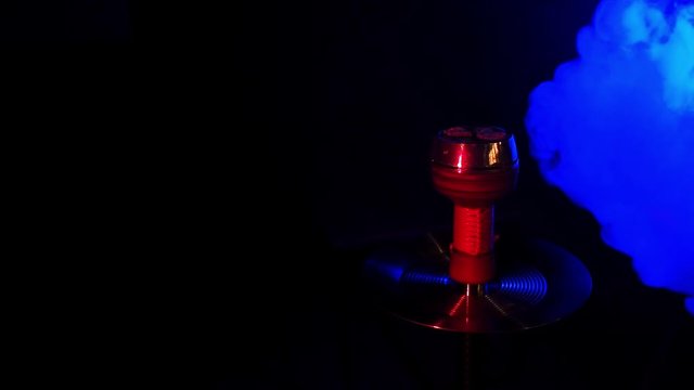hot red charcoals in a metal hookah shisha bowl with blue smoke