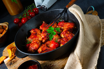 Spicy chicken wings in honey with potato wedges