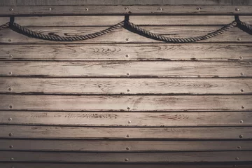 Foto op Aluminium De zijkant van een oude houten boot met scheepstouw. Mariene houtstructuur achtergrond met kopie ruimte. © Andrey_Maksimov