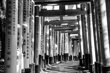Red wooden torii Gate at Fushimi Inari Shrine in Kyoto, Japan. One of the popular site in Kyoto. Picture in black and white.