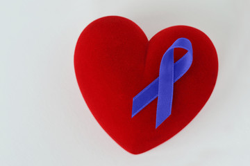Heart with blue ribbon on white background - Concept of prostate cancer awareness