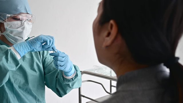綿棒でウイルス検査をする医師