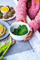 Cooked, steamed, boiled spinach greens. Vegan lunch food on table.