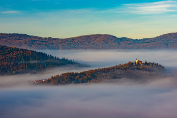 the church on the hill and fir trees on an autumn day