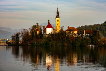 Fototapeta na wymiar bled lake at sunset and lights reflected on the water