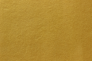 Naklejka premium Gold paint on cement wall texture or backgrond