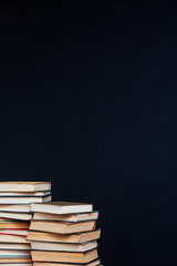 many stacks of educational books in the university library on a black background