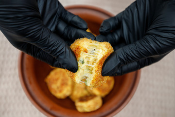 fried potato cutlets in a bowl and in the hands of a person
