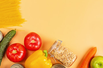 Donation bag with various food on orange background with copy space. Flat lay. top view, Mockup. Food donations or food delivery service concept. Online shopping during coronavirus covid-19 lockdown