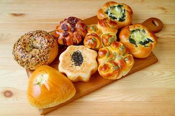 Naklejka na ściany i meble Delectable assorted sweet and savory breads on a wooden tray served on wooden table