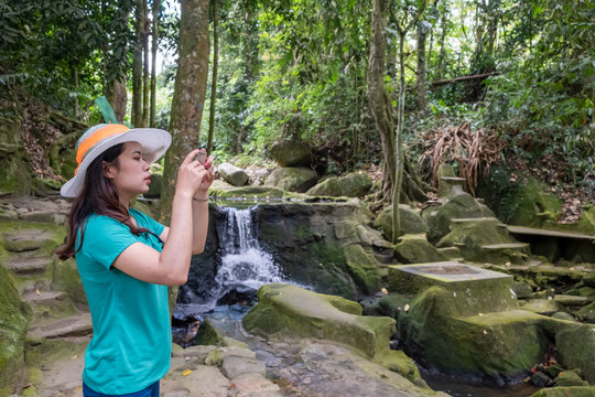 Young thai woman taking photos with beautiful nature park after quarantine home stay.