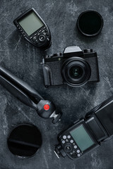 Set of the camera and photography equipment (lens, tripod, filter, flash, camera, trigger) on grey background. Professional photographer accessories.