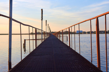Fototapeta na wymiar Iron footbridge over the lake