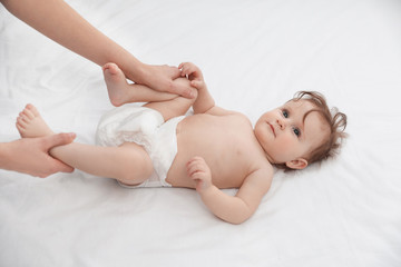 Obraz na płótnie Canvas Orthopedist and cute baby on white bed