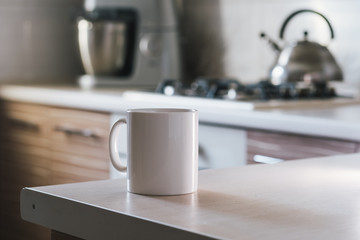 White cup of coffee on the table in the kitchen